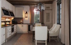 a kitchen with white cabinets and a table and chairs at Luxury resort in Palūkštis +4 photos