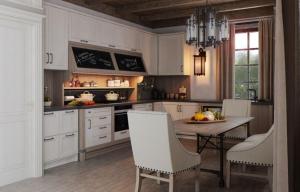 a kitchen with white cabinets and a table and chairs at Luxury resort in Palūkštis