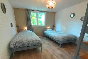 a bedroom with two beds and a window at CHALET ARDENTARDENNE - Durbuy in Durbuy