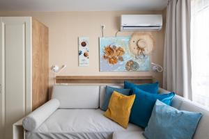 a living room with a couch with blue and yellow pillows at Aquamarine in Pomorie