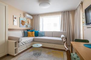 a living room with a couch and a window at Aquamarine in Pomorie