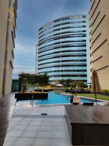 a large building with a swimming pool in front of a building at Al Raha Serenity - Spacious 2BR Getaway Near Yas Island & Al Raha Beach in Abu Dhabi