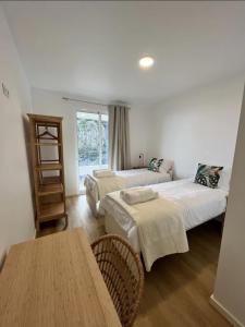 a hotel room with two beds and a table at Ribeira Roots Residence in Santa Cruz