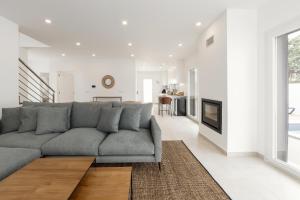 a living room with a gray couch and a fireplace at Casa Branca in Óbidos