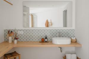 Un mostrador de baño con un lavabo y un espejo. en Agroturismo Ses Talaies, en Ciutadella 39 fotos más