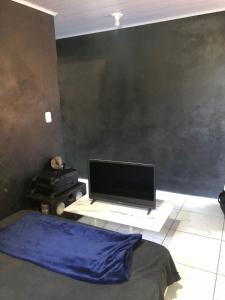 a bedroom with a tv on a table with a bed at Casa próximo ao centro in Uruguaiana