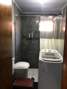 a small bathroom with a toilet and a shower at Casa próximo ao centro in Uruguaiana