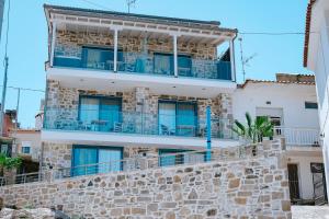a building with a balcony on top of a stone wall at Evaggelia's Stone Suites in Skala Marion