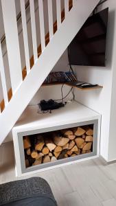 a fireplace under the stairs with logs in it at Apartment Loft Pejić - open space loft studio near Bovec, Soča Valley in Bovec
