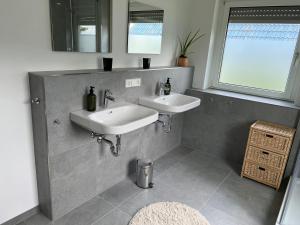 a bathroom with two sinks and a window at Ferienhaus am Schorren in Bad Schussenried +14 photos