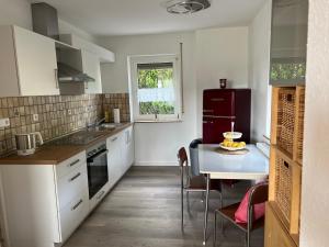 a kitchen with a table and a red refrigerator at Ferienhaus am Schorren in Bad Schussenried