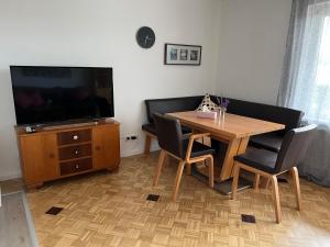 a living room with a wooden table and a television at Ferienhaus am Schorren in Bad Schussenried
