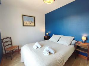 a bedroom with a large white bed with towels on it at Le Balnéo Duplex avec balcon - Riva Bella Plage in Ouistreham
