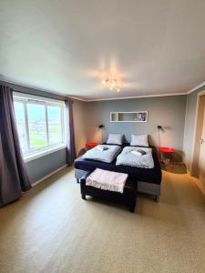 Un dormitorio con dos camas y una gran ventana. en Casa Melkhaugen, en Veiholmen 6 fotos más