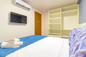a bedroom with a bed with a tv on the wall at Marina do Cupe 302 in Porto De Galinhas +15 photos