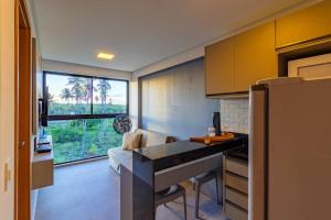 a kitchen with a counter top and a large window at Marina do Cupe 302 in Porto De Galinhas