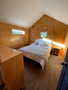 カストロにあるLos Robles de Quilquicoの木製の壁の部屋にあるベッドのある寝室