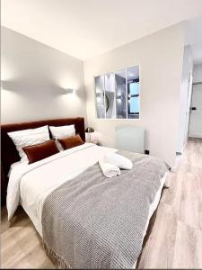 a white bedroom with a large bed in it at Le Croix d'Or - Plein centre ville in Chambéry
