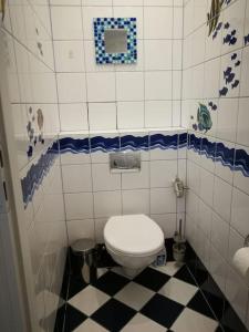 Un baño con inodoro blanco y suelo blanco y negro. en Spokojne w samym centrum, en Wroclaw