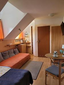 a bedroom with a bed and a table and a kitchen at Pokoje Gościnne u Stasi in Mielno