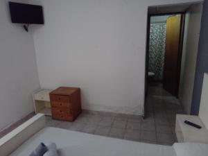 a room with a bed and a dresser and a television at JONATAN II Bed & Breakfast in Mina Clavero