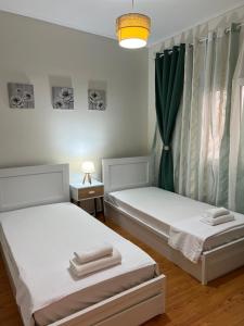 a room with two beds and a lamp at Acropolis Sidewalk view in Athens