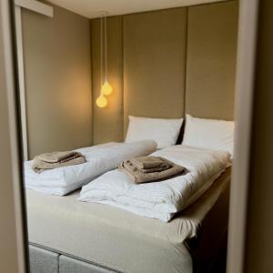 two towels are sitting on top of two beds at Cozy Central Apartment in Ålesund in Ålesund