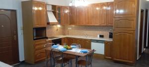 a kitchen with wooden cabinets and a table and chairs at Gamila Sunrise in Konitsa