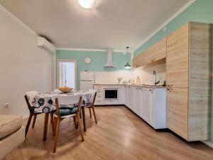 a kitchen with a table and chairs in a room at Apartment Harmonia in Dramalj