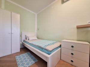 a small bedroom with a bed and a dresser at Apartment Harmonia in Dramalj