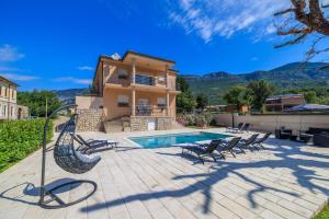 una villa con piscina y una casa en Apartments Margita 2, en Tribalj