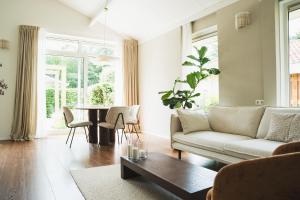 皮滕Bed en Wellness Groenrust Putten的客厅里有一张沙发和一张桌子。