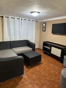 a living room with a couch and a flat screen tv at El Cayuco Restaurant Apart Hotel in Boca Chica