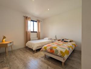 a bedroom with a bed and a desk and a window at Maison TESLA aéroport gare cnpe rte Golf de Lyon in Jons