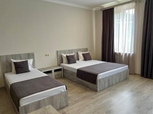 a hotel room with two beds and a window at Menua by Horizon Hotels, Yerevan in Yerevan