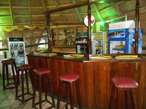 a bar with red stools at a bar with aperature at Panorama Cottages in Kalangala