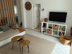 een woonkamer met een bank en een tv bij Apartamento 90m2 com vista mar - Albufeira in Albufeira