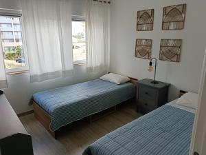 twee bedden in een kleine kamer met twee ramen bij Apartamento 90m2 com vista mar - Albufeira in Albufeira