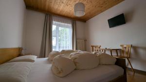 a bedroom with a bed with white pillows on it at Garni Diamant in Colfosco