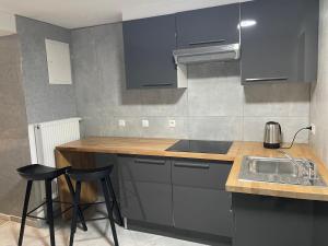a kitchen with blue cabinets and a sink and stools at Jungle suite romantic - private Jacuzzi - in Brussels