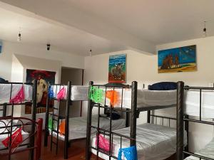 a room with four bunk beds in it with paintings at Hostal Mil Máscaras in Oaxaca City
