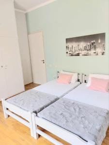 two beds in a room with white walls and pink pillows at Φωτεινό δίκλινο δωμάτιο με θέα! in Athens
