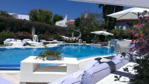a swimming pool with white chairs and a table at Villa Rosamarina in Rosa Marina