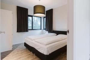 Ένα ή περισσότερα κρεβάτια σε δωμάτιο στο Luxe Villa op park Duinzicht (huis 705) - Ouddorp