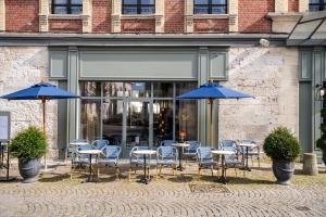 オンフルールにあるL'INVITATION AU VOYAGE - Hôtel & Spaの青い傘を置いたテーブルと椅子