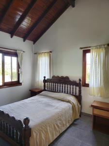 a bedroom with a large bed and two windows at Casa Chalet in Ostende