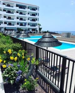 a balcony of a hotel with a pool and umbrellas at Sun Studio Tenerife in Arona