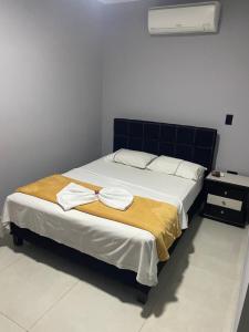 a bed with two towels on it in a room at hotel escorial neiva in Neiva