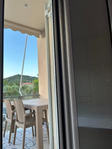 a table and chairs on a balcony with a view at Κτήμα Καρνέση 1 in Edipsos
