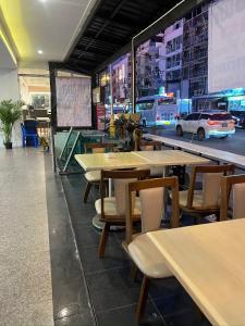a restaurant with tables and chairs and a car on a street at Patong Dynasty Royal Hotel in Patong Beach